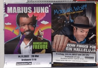 Ein älterer Ausschnitt einer Plakatwand mit einem Plakat von Marius Jung Soloprogramm und Manuel Wolffs Soloprogramm.
